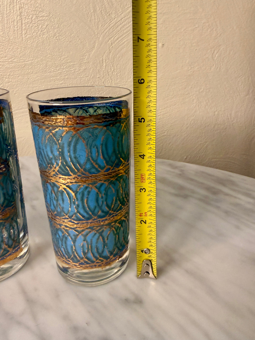Three vintage Georges Briard highball glasses with blue interlocking oval patterns and 22-karat gold detailing.
