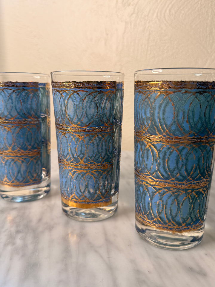 Three vintage Georges Briard highball glasses with blue interlocking oval patterns and 22-karat gold detailing.