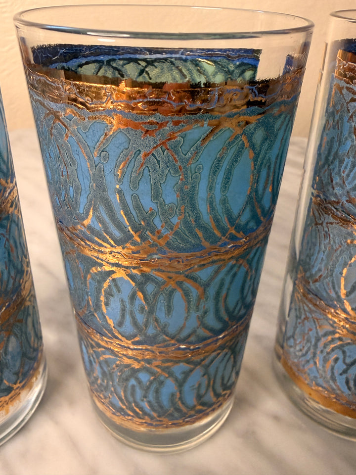 Three vintage Georges Briard highball glasses with blue interlocking oval patterns and 22-karat gold detailing.