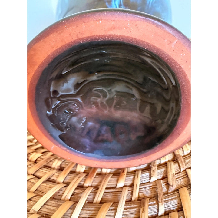 Vintage Rainbow Ceramics vase with blue, teal and copper drip glaze over black, an elongated rounded body, flared opening and pedestal base.